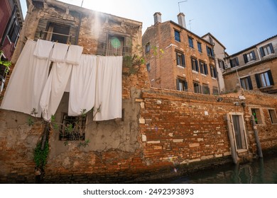 Venice, Italy - June 05, 2024: Laundry Drying Above Venetian Canal. Glare from the sun on top. - Powered by Shutterstock