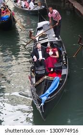 Venice / Italy - June 19 2016: Couple Going To Masquerade Ball Riding On Gondola In Venice Italy.