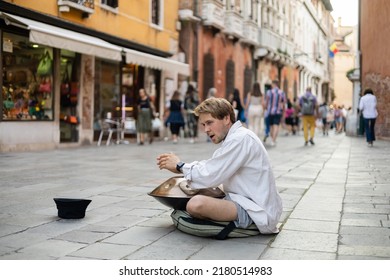 VENICE, ITALY - MAY 22, 2022: Street Musician Performing Hand Drum On Urban Street