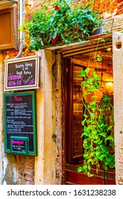 Venice, Italy - November 02 2018: Happy Hour Sign/ Signboard/ Chalkboard Outside A Venetian Bar With Breakfast Menu. Brick Wall Building Architecture And European Outdoor Culture Hanging Potted Plants