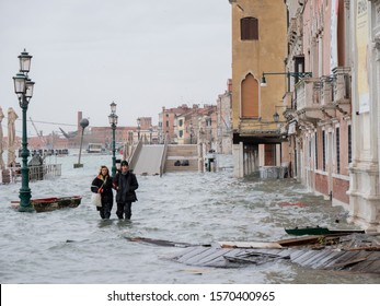 VENICE, ITALY - November 13, 2019: Tourists walking on the flooded sidewalks aside to the canal, Italy. 4k