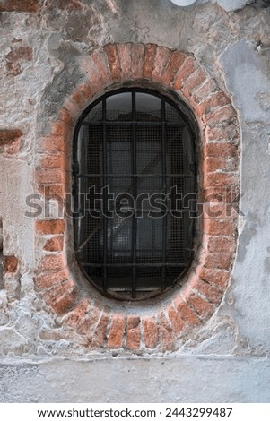 Venice, oval window, barred, surrounded with brick stones