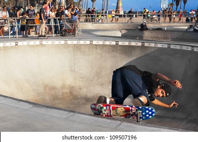  VENICE-AUG 4: A Skateboarder Skates Sideways Along The Edge Of A Bowl While A Crowd Watches Him At The Venice Skatepark In Venice, CA On Aug. 4, 2012. 