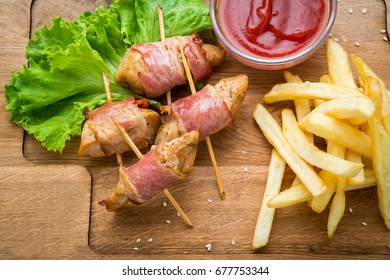 Venison kebab and rasher of crispy bacon. Wooden background