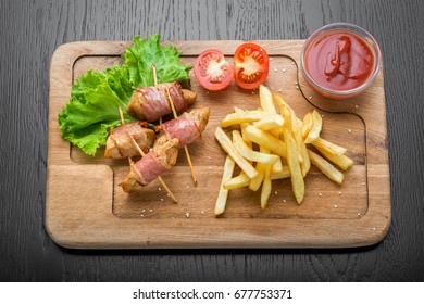 Venison kebab and rasher of crispy bacon. Wooden background