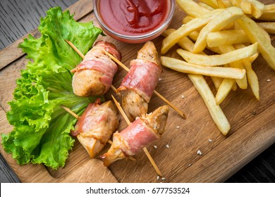 Venison kebab and rasher of crispy bacon. Wooden background