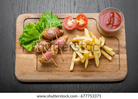 Venison kebab and rasher of crispy bacon. Wooden background