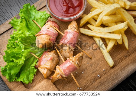 Venison kebab and rasher of crispy bacon. Wooden background