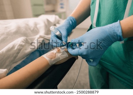 Venous access being established in a patient’s hand by a medical professional