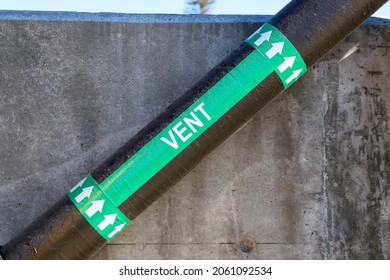 Vent marker on pipe with an arrow to indicate flow