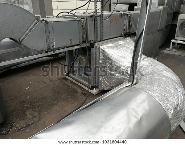 Ventilation exhausting\
fan with exhaust vented ventilation pipes standing on the roof of\
the business\
center.