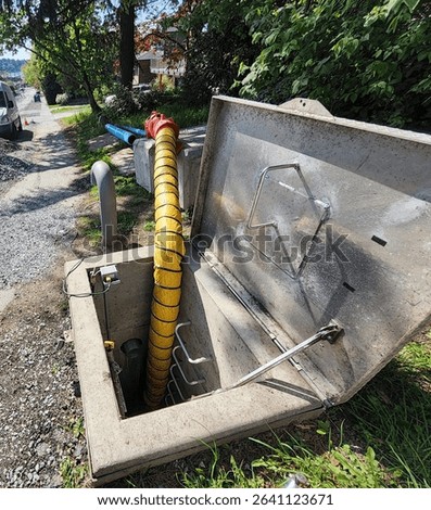 Ventilation hose inserted into utility vault to extract fumes and ensure confined space safety for workers.