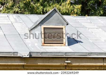 Ventilation pipe with grille on the roof of a building.
