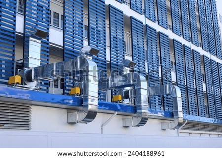 Ventilation pipe outside the building. Ventilation system with shiny metal square pipe with outdoor motor with copy space and select focus.