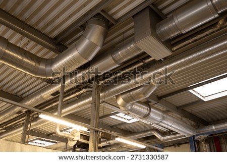 Ventilation pipes along the ceiling inside a building, part of the HVAC system and indoor infrastructure.
