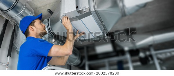 ventilation system installation and\
repair service. hvac technician at work. banner copy\
space