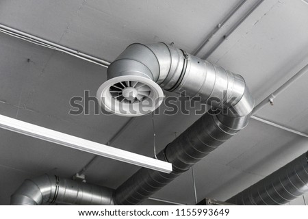 Ventilation system on the ceiling of large buildings. Ventilation pipes in silver insulation material hanging from the ceiling inside new building.