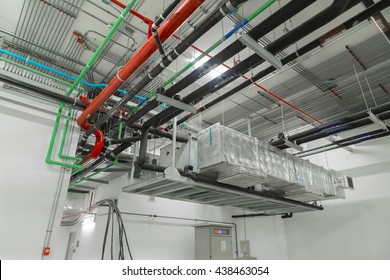 Ventilation system and pipe systems installed on industrial building ceiling.