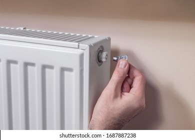 Venting the radiator. The man's hand holds a special key which he inserts into the vent valve.