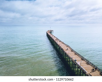 Ventura pier during early summer. great for fishing, suntanning, eating tacos, and walking along the wooden deck. water aqua clear. california beaches and clear skies with clouds