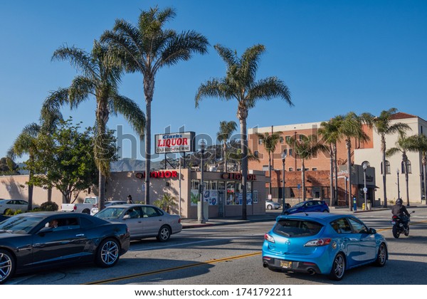 Ventura, United States - February 21 2020 :\
an alcoholic beverages store in Ventura with palm trees around\
advertises with a huge liquor sign on the\
roof