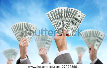 Venture capital or crowd funding finance and investment concept businessmen holding up dollar currency aloft