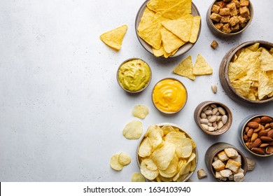Veraity bowls of beer snacks and sauces on stone table. Nuts, chips, nachos, crackers. Top view with copyspace - Powered by Shutterstock - Get 15% off with code: PIKWIZARD15