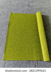 Verdant Rows: An Array of Plain Green Carpet Rolls
​ABOUT
​This clean, studio-styled collection photograph presents a refreshing, orderly arrangement of plain, unpatterned green carpet and rug rolls, creating an abstract study in solid natural color blocking and cylindrical geometry. The styling is clinical and minimalist, showcasing slender and heavy-duty rolls of textile flooring in various luminous shades of emerald, forest green, and lime against a clean backdrop.
​Texturally, the image captures the dense, non-woven matrix of heavy synthetic fibers designed for commercial and exhibition flooring. The surface of each roll is matte and velvety, absorbing directional light uniformly while casting soft, rounded contours along the curved spines of the cylinders. The microscopic irregularity of the matted threads provides a warm, tactile contrast to the rigid, clean-lined composition. This high-impact visual asset serves as a versatile background for modern interior design, commercial flooring catalogs, and corporate architectural portfolios.