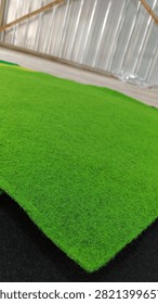 Verdant Rows: An Array of Plain Green Carpet Rolls
​ABOUT
​This clean, studio-styled collection photograph presents a refreshing, orderly arrangement of plain, unpatterned green carpet and rug rolls, creating an abstract study in solid natural color blocking and cylindrical geometry. The styling is clinical and minimalist, showcasing slender and heavy-duty rolls of textile flooring in various luminous shades of emerald, forest green, and lime against a clean backdrop.
​Texturally, the image captures the dense, non-woven matrix of heavy synthetic fibers designed for commercial and exhibition flooring. The surface of each roll is matte and velvety, absorbing directional light uniformly while casting soft, rounded contours along the curved spines of the cylinders. The microscopic irregularity of the matted threads provides a warm, tactile contrast to the rigid, clean-lined composition. This high-impact visual asset serves as a versatile background for modern interior design, commercial flooring catalogs, and corporate architectural portfolios.