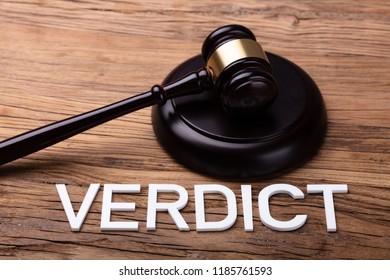 Verdict Text In Front Of Brown Gavel On Wooden Table