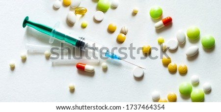 Verity of colorful medicial pills with syringe on white background. Medical concept.