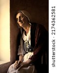 Vermeer or Rembrandt style portrait of a woman sitting at her window