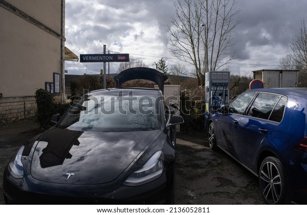 Vermenton, France - February 23 , 2022: A static\
shot of a solid black Tesla Model 3 dual motor long range awd\
charging at the DC Freshmile charging station in a cloudy winter\
day. Selective\
focus.