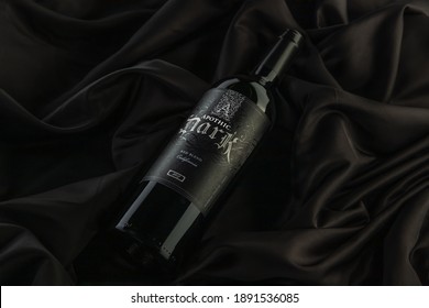 Vero Beach, Florida; USA; Dec. 7, 2020. A Flat Lay, Top Down View, Of A Bottle Of Apothic Dark Red Wine. The Wine Bottle Is Photographed On A Wrinkled Silk Cloth Surface. Dark And Moody Lighting.