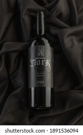Vero Beach, Florida; USA; Dec. 7, 2020. A Flat Lay, Top Down View, Of A Bottle Of Apothic Dark Red Wine. The Wine Bottle Is Photographed On A Wrinkled Silk Cloth Material Surface. Dark And Moody Light