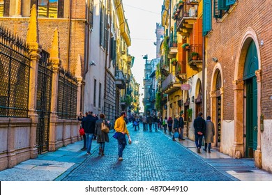 VERONA, ITALY, MARCH 19, 2016: people are strolling through a narrow street towards Dominican church of Santa Anastasia in Verona, Italy