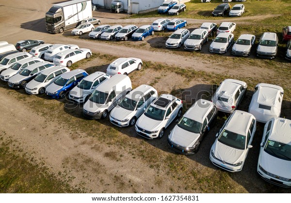 Verona, Italy - October 21, 2019: Many brand new\
cars covered in protective foil on sale parked outside on dealer\
parking lot.