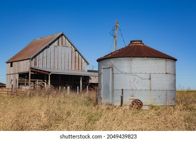 Versailles, Missouri - November 30 2019: A rusted barn and grain bin in the rural farmland. 