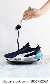 Versailles/France - 19/04/2020: A Shoelace Of A Puma Sport Sneaker Is Being Rolled On A Fork Like Pasta. Message: To Eat Or To Work Out? 