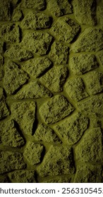 A vertical 4K background featuring a grainy stone wall in dark olive green tones, ideal for rustic backdrops, banners, and textured wallpaper designs