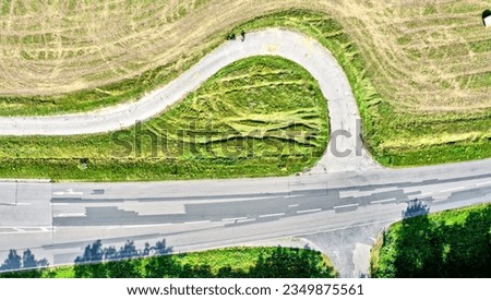 Vertical aerial view of an arched turnoff on a paved bike path