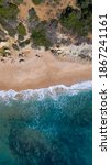 Vertical Aerial view of the beach of Los Castillejos with sand and blue sea with transparent water. Top view, amazing natural beach background. Atlantic Ocean in Caños de Meca, Cádiz, Andalusia, Spain