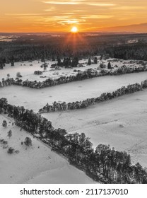 A Vertical Aerial View Of A Snowy Mountain Village At Sunset