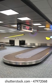 Vertical Airport Baggage Claim Carousel.  Some Carts On The Left, Top Reads 