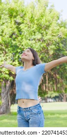 Vertical Of Asian Carefree Woman Take Deep Breath And Stretching Her Arms In The Park