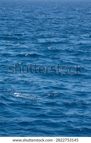 Vertical background frame of rippled blue ocean water glistening under bright daylight in Canary Islands.