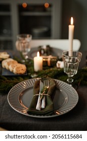 Vertical background image of black table setting decorated for Christmas with candles lit, copy space