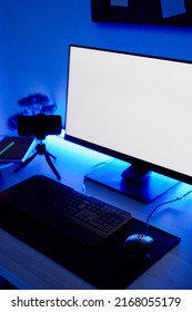 Vertical background image of gaming setup PC on desk lit with blue neon lighting, screen mockup