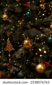 Vertical background image of glittering Christmas tree decorated with golden baulbs copy space