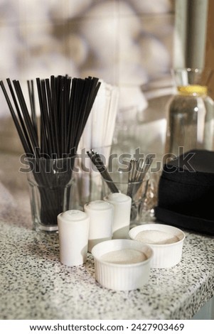 Vertical background image of service setup with salt pepper sugar and straws at self service table in coffee shop